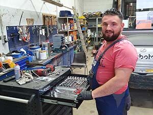 Ein Mann steht vor einer Werkzeugkiste in einer Garage.