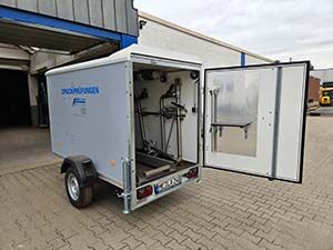 Ein kleiner Druckprüfanhänger mit einer offenen hinteren Tür.<br />