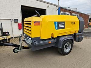 Ein große orangefarbener Anhänger als Schweißaggregat.