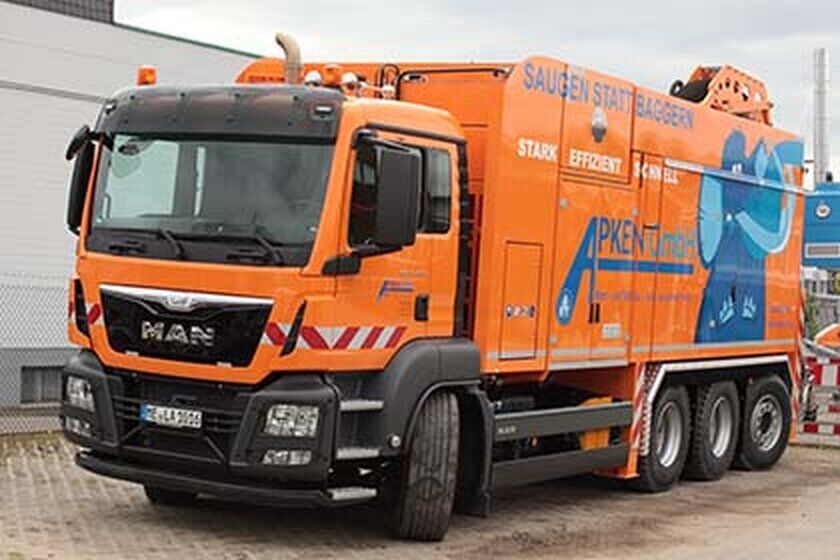 Saugwagen - Apken GmbH Ein großer orangefarbener Saugwagen von vorne rechts.