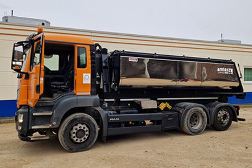 Thermocontainer - Apken GmbH Ein großer orangefarbener Thermocontainer steht vor einem Gebäude.